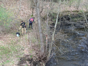 Stephen Ojeda-Britez and Travis Register clean up around the creek and under the bridge on the SUNY Poly Utica campus.