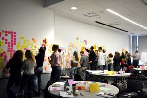 suny poly innovation challenge 2014. Students posting sticking notes with ideas to wall.