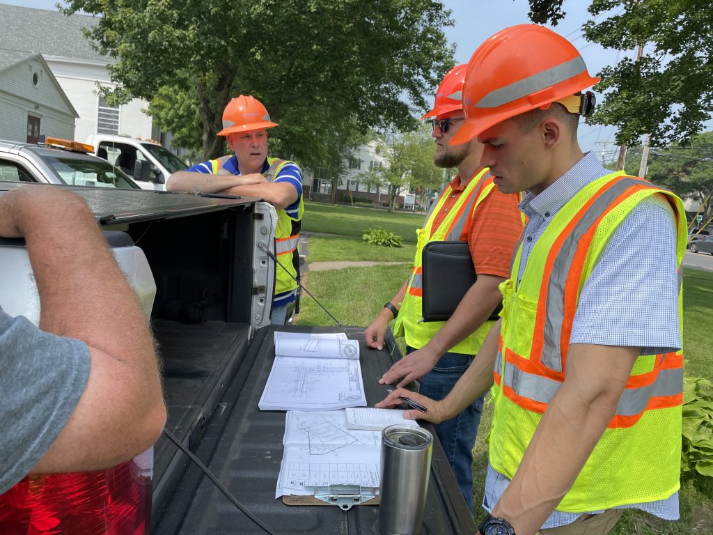 Roach with colleagues in the field looking at a job plan.
