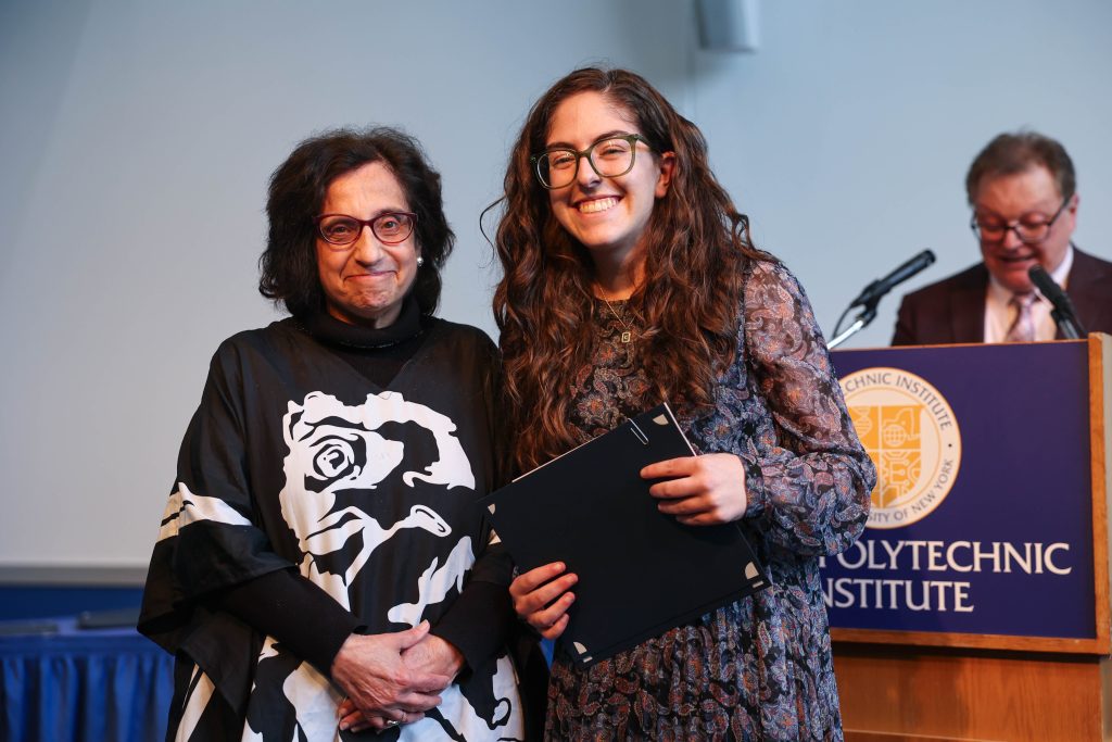 Carly Pimpinella holding an academic award presented to her by Dr. Joanne Joseph, who is also pictured. 