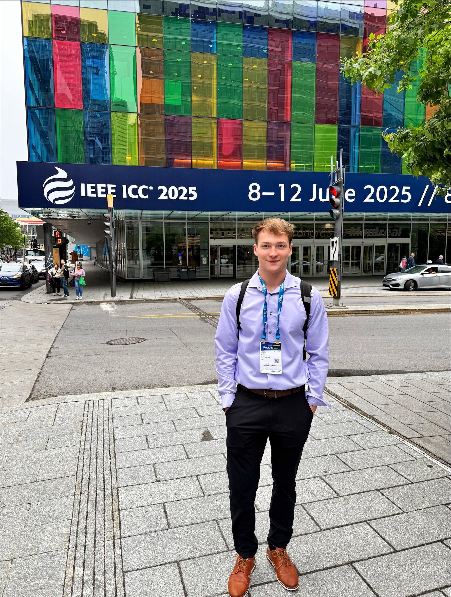 SUNY Poly Senior Justin Osmond pictured in Montreal where he presented at a conference. He is wearing professional attire, light blue dress shirt, dark slacks, brown dress shows. He is has darker blonde hair.