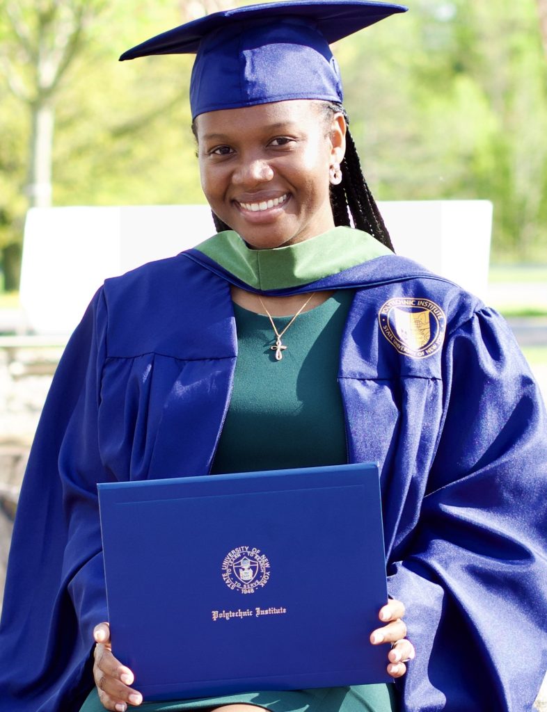 Shakeil Thomas in her cap and gown holding up her blue SUNY Poly degree.