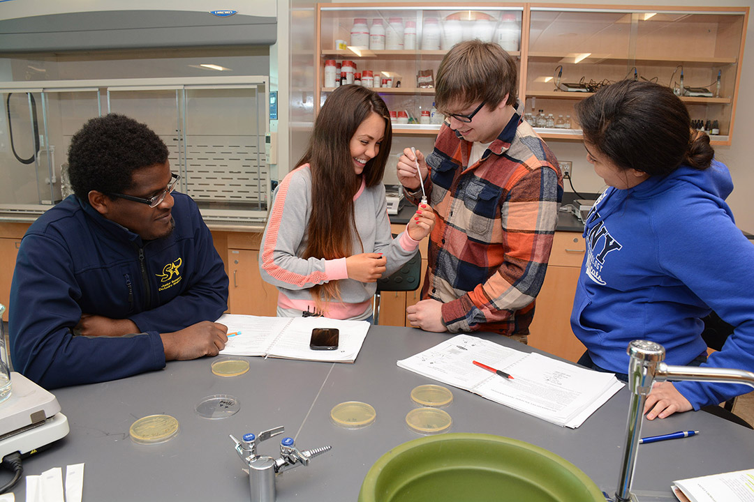 students in a lab putting liquid into a vial