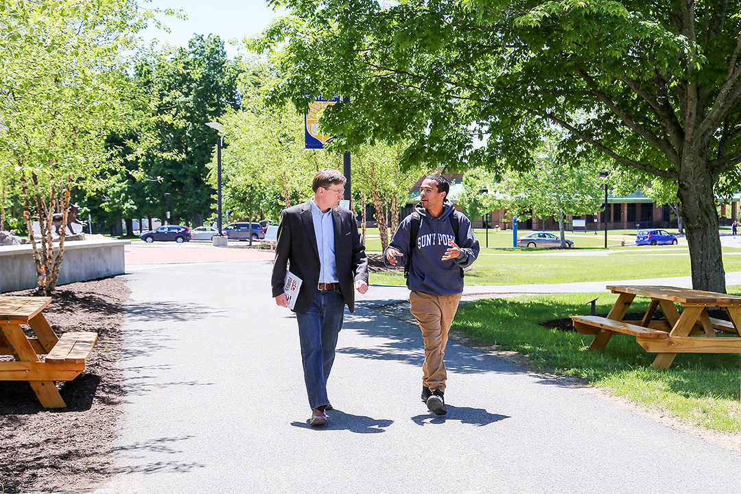student walking with a professor on campus