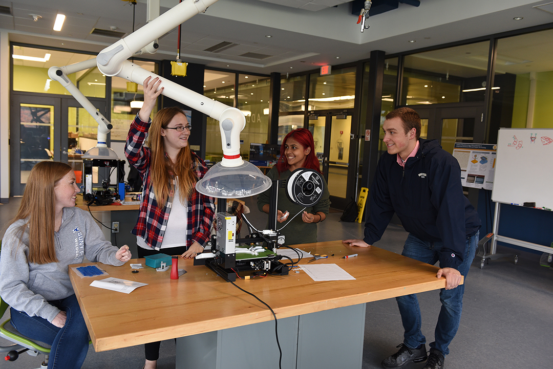 students sitting around a table in a robotics lab